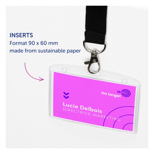 Bilden visar en namnskylt eller ett badgefack med en rosa insats. Brickan har namnet 'Lucie Delbois' och titeln 'DIRECTRICE MARKETING'. Den har ett klämma och beskrivs som gjord av hållbart papper. Storleken anges som 90 x 60 mm.