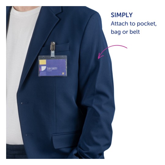 En närbild av en person som bär en blå jacka med en fastsatt namnskylt där det står 'JEAN LAMIPU' följt av ordet 'fotograf.' Det finns en textinstruktion till höger som föreslår att fästa den på en ficka, väska eller bälte.