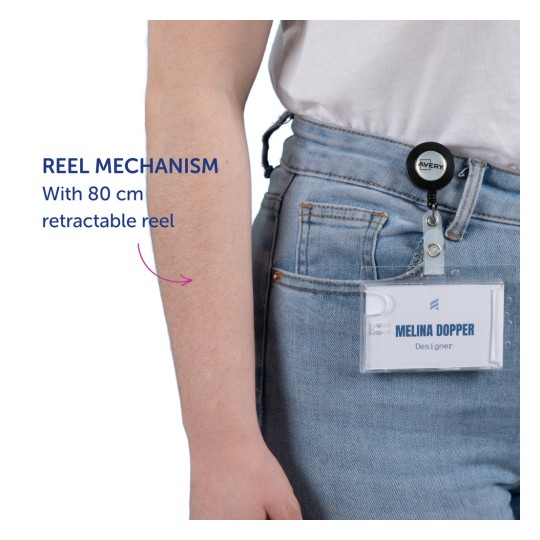 Bilden visar en persons arm med en utdragbar badgevinda. Vindan är fäst vid en namnbricka som lyder 'MELINA DOPPER, Designer' och visar dess utdragbara funktion på 80 cm.