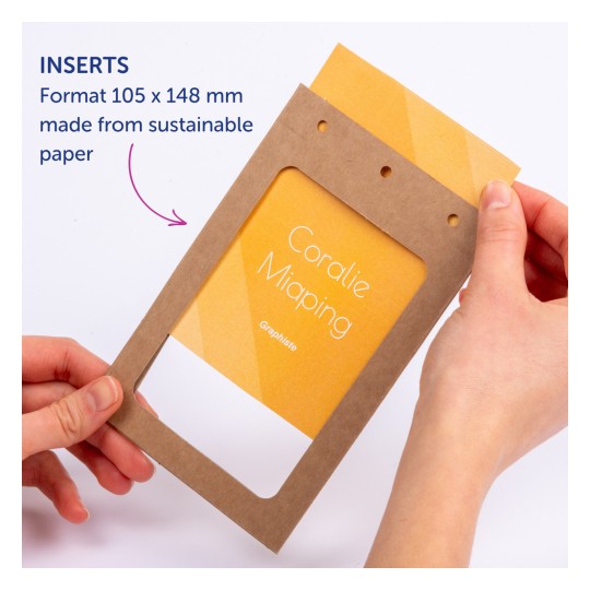 Bilden visar en person som håller en brun pappersram med en gul insats som visar namnet 'Coralie Miaping'. Ramen har hål och är märkt 'Inserts' med information om dess storlek och hållbart material.