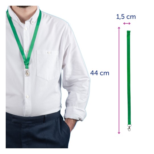 Bilden visar en person som bär en grön nyckelband runt halsen. Nyckelbandet har en klämma och måtten 44 cm i längd och 1,5 cm i bredd. Personen är klädd i en vit skjorta och marina byxor.