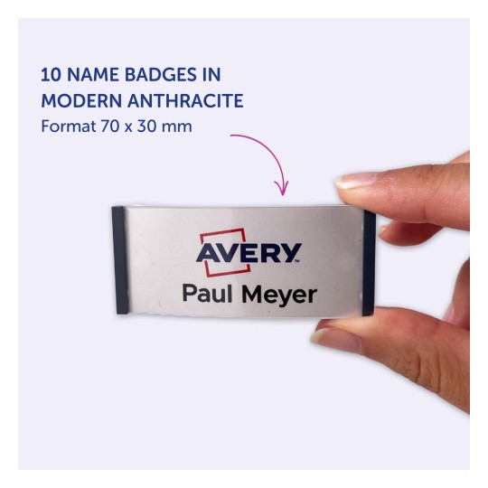 Bilden visar en namnbricka från Avery, som visar namnet 'Paul Meyer' och information om brickans format, vilket är 70 x 30 mm. Det anger att det finns 10 namnskyltar i modern antracitfärg.