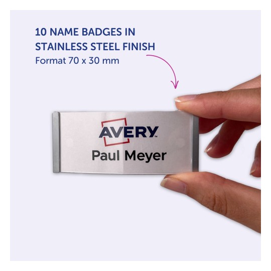 Bilden visar en hand som håller en namnbricka i rostfritt stål. Brickan har namnet 'Paul Meyer' och logotypen för 'Avery'. Den anger att produkten innehåller 10 namnskyltar med måtten 70 x 30 mm.