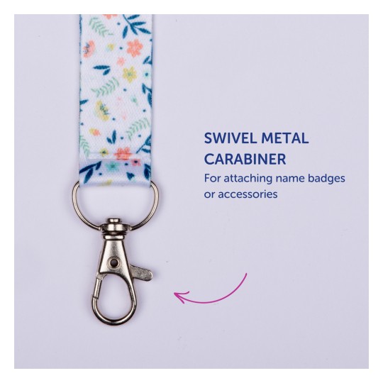 Bilden visar ett färgglatt nyckelband med ett blommigt mönster och en vridbar metallkarbinhake, märkt som 'Vridbar metallkarbinhake för att fästa namnskyltar eller tillbehör'.