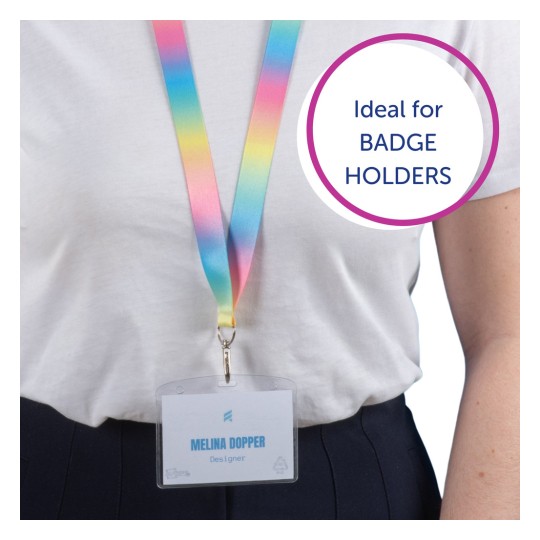 Bilden visar en person som bär en färgglad nyckelrem med ett märke där det står 'Melina Dopper, Designer.' Nyckelremmen övergår från rosa till gult till blått, och det finns en pratbubbla som säger 'Idealisk för ID-KORTHÅLLARE.'
