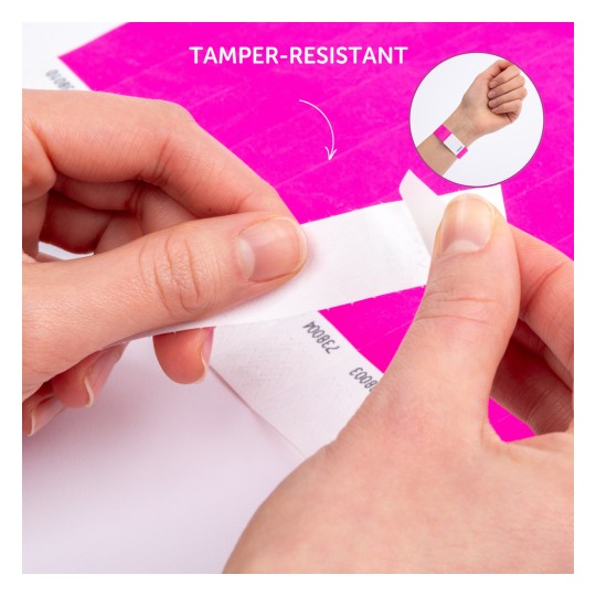 Bilden visar en persons händer som lossar ett manipuleringssäkert armband från ett ark. Bakgrunden har en ljusrosa färg, och en mindre infälld bild visar armbandet applicerat på en handled.