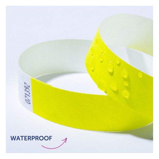 Bilden visar ett gult vattentätt armband med vattendroppar på ytan, vilket indikerar dess vattenresistenta egenskap.
