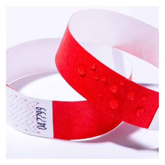 Bilden visar två armband, ett rött och det andra en blandning av rött och vitt med ett sicksackmönster. Det röda armbandet har vattendroppar på sin yta.