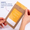 Bilden visar en person som håller en brun pappersram med en gul insats som visar namnet 'Coralie Miaping'. Ramen har hål och är märkt 'Inserts' med information om dess storlek och hållbart material.