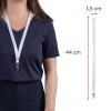 Bilden visar en person som bär en mörk skjorta med ett vitt nyckelband runt halsen. Nyckelbandet har dimensionerna angivna: 44 cm i längd och 1,5 cm i bredd, tillsammans med ett klips i änden.