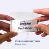 Bilden visar en person som håller en namnbricka med Avery-loggan och namnet "Paul Meyer" på den. Namnbrickan verkar vara lätt att sätta in i en hållare gjord av robust papper.