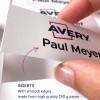 Bilden visar en hand som håller en tryckt insats med texten 'Paul Meyer' och AVERY-loggan, som understryker detaljer om att insatserna är tillverkade av högkvalitativt papper med släta kanter.