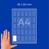 Hand bredvid ett diagram på ett A4-ark märkt 30 x 50 mm med små rektangulära rutor?