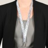 Bilden visar en person som bär en svart blazer över en grå skjorta, med ett färgglatt blommigt nyckelband runt halsen som håller ett ID-kort.