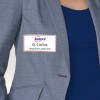 Bilden visar en person i en grå kavaj med en namnbricka som lyder 'B. Carlos, Marknadschef' tillsammans med Avery-logotypen.