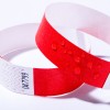 Bilden visar två armband, ett rött och det andra en blandning av rött och vitt med ett sicksackmönster. Det röda armbandet har vattendroppar på sin yta.